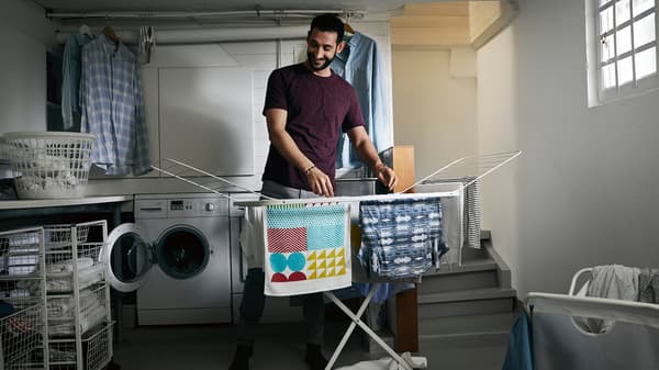 Man hanging laundry on a drying rack