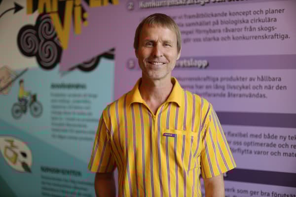 Man med gul IKEA-tröja står och ler mot kameran