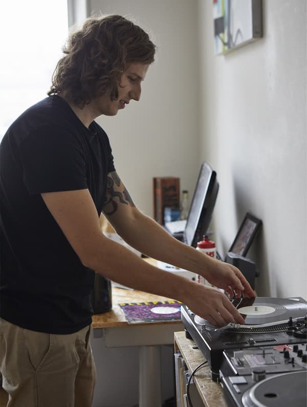Man playing records in his bedroom.