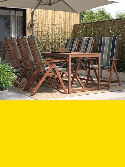 Man sieht einen Balkon mit einem Gartentisch mit sechs Hochlehnern inklusive Sitzpolster und darunter einen gelben Balken.