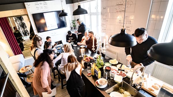 Många männiksor står runt en köksö där en frukostbuffé är uppdukad. 