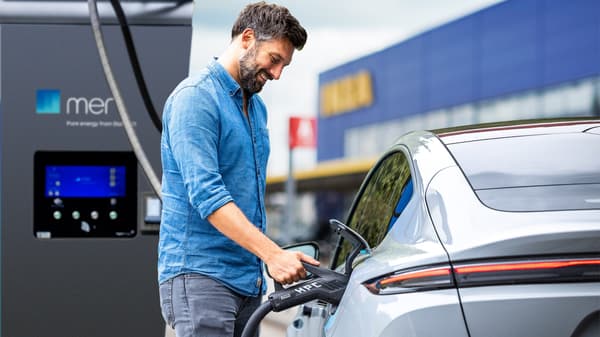 Mann auf IKEA Parkplatz der sein Auto läd