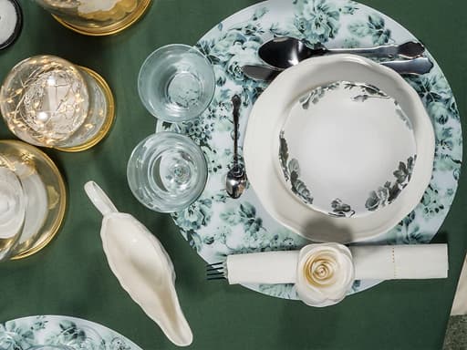 Mantel individual, cunca, copa de viño, vaso, xogo de cubertos e salseira para unha mesa de Nadal elegante