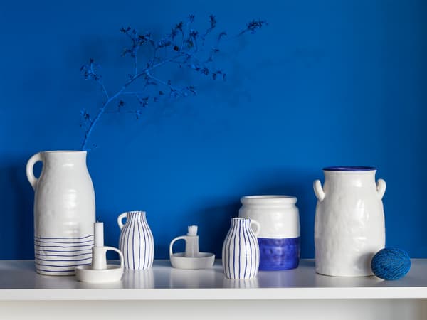 Many GODTAGBAR vases made in stoneware and hand-painted in white and blue, as well as a candlestick in the same series.