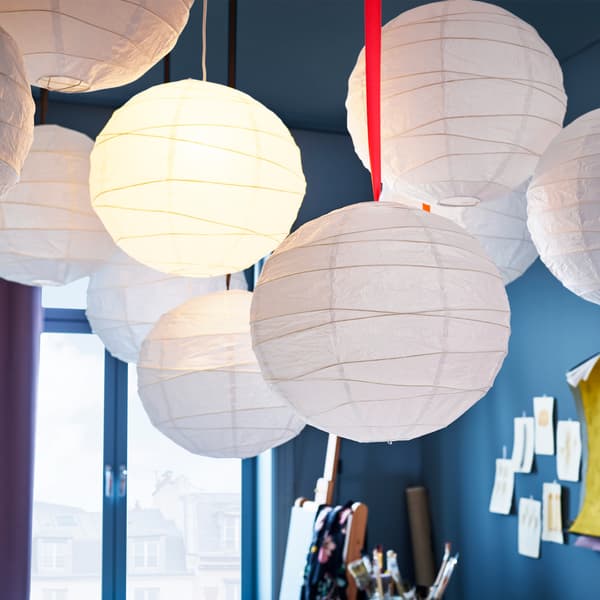 Many white REGOLIT pendant lamp shades that are made from rice paper.