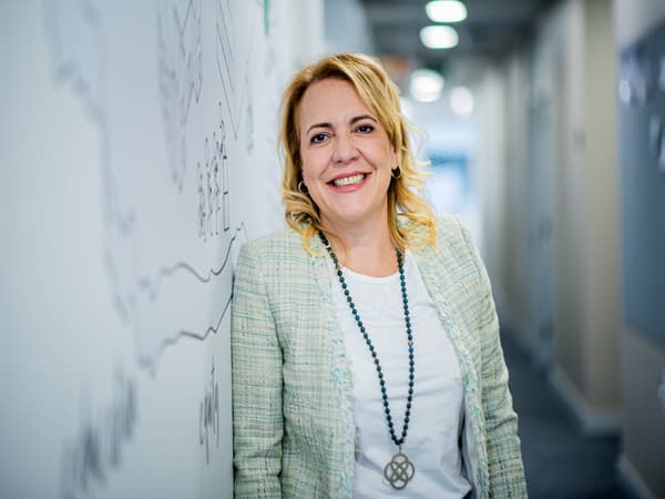 Maria Marante, Customer Experience & Operations Manager de IKSO, apoyada en una pared blanca con frases.