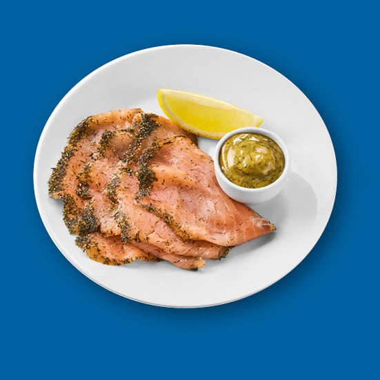 Mariniran losos z gorčično omako in limono na modri podlagi