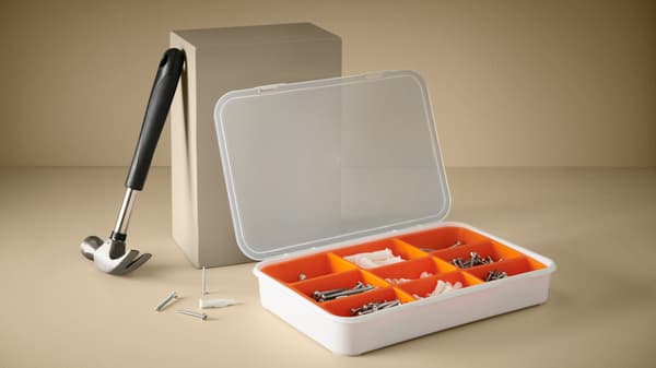 Martillo apoyado en una caja de organización con tornillos.