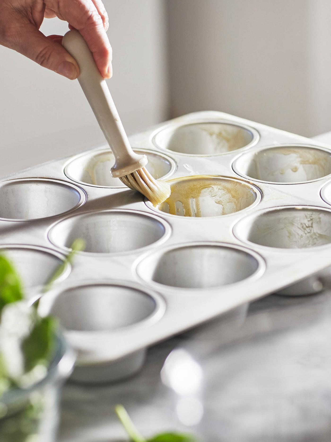 Mašlovačka LÄTTBAKAD potírá máslem formu na muffiny VARDAGEN.