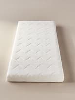 Matalàs rectangular blanc amb un patró de costures en zig-zag sobre una superfície encoixinada. Disseny senzill i funcional, ideal per a llits individuals o infantils.