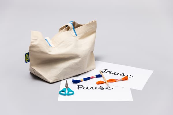Material liegt auf einem weißen Tisch. Stickgarn in verschiedene Farben​
Sticknadel​, Vorlage , Bleistift, Schere und eine SPIKRAK Tasche.