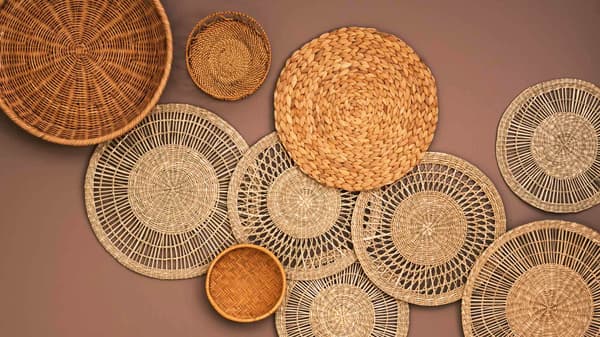 Mauve wall with round wall decor of various sizes made with natural fibres.