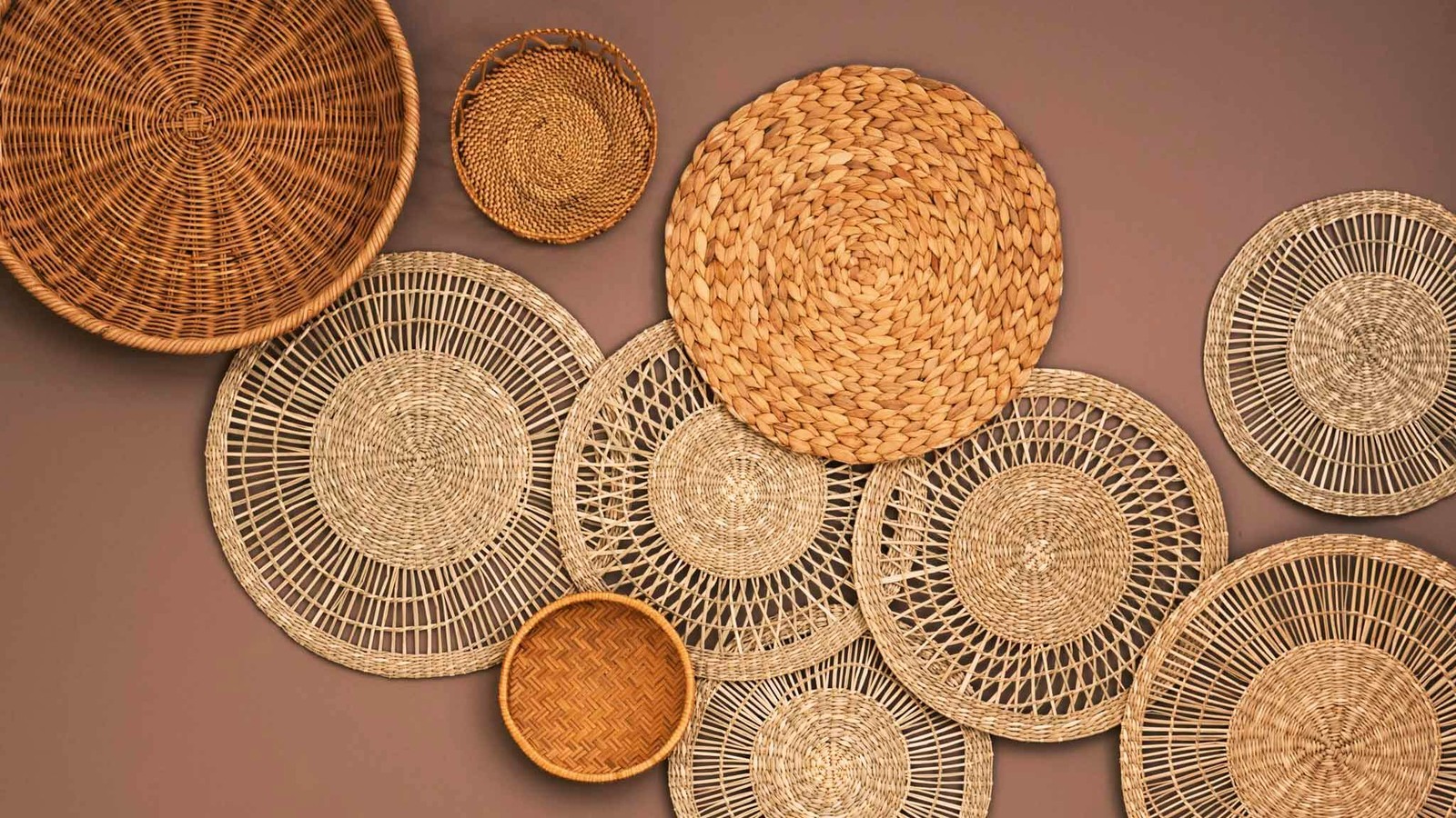 Mauve wall with round wall decor of various sizes made with natural fibres.