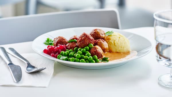 Meatballs with mash and peas on a white plate
