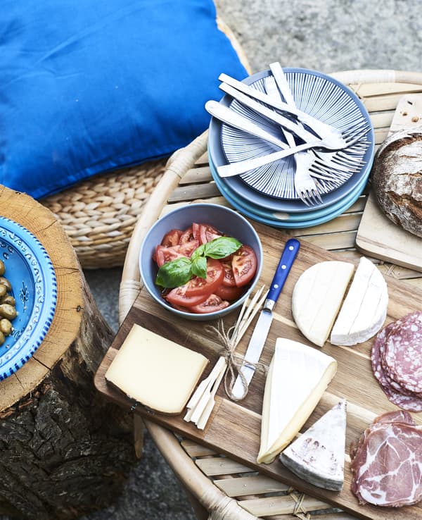 Meats, cheeses and blue crockery on a coffee table.