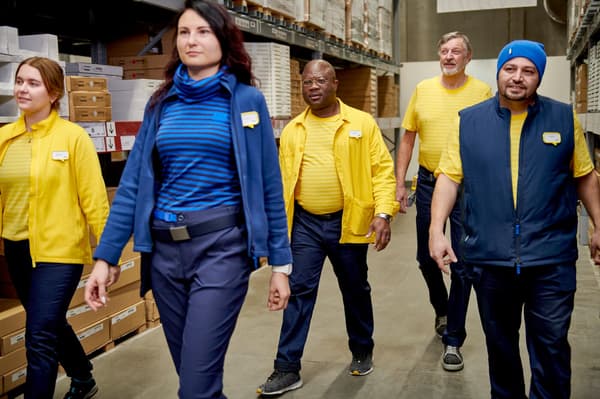 Mehrere IKEA Mitarbeitende laufen durch ein Lager