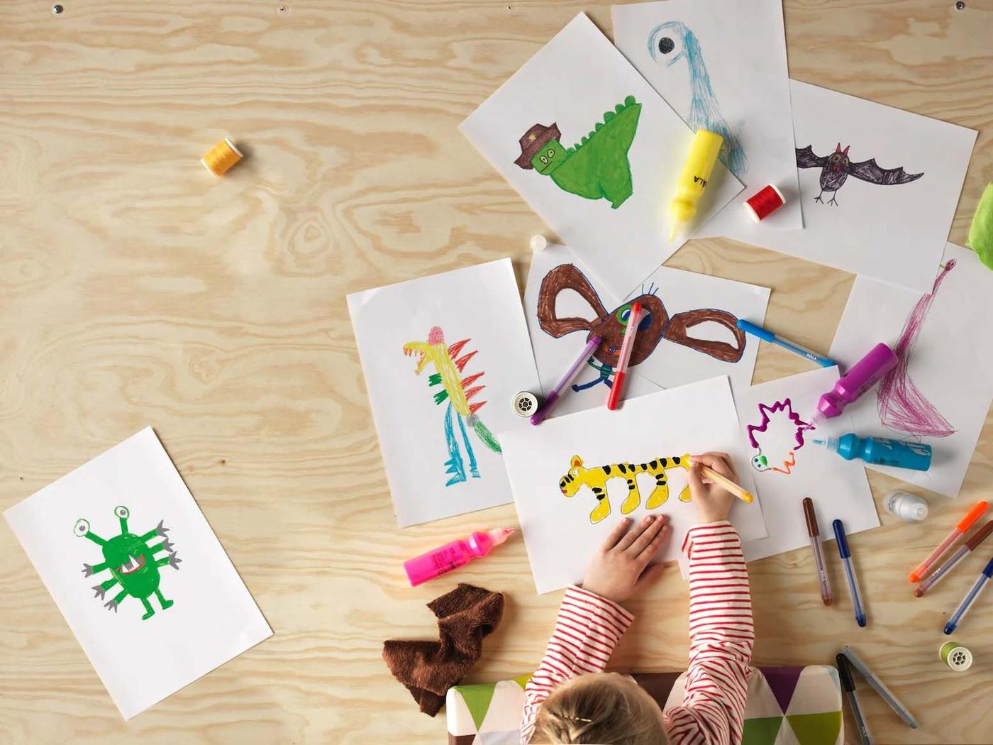 Menina a desenhar e a colorir