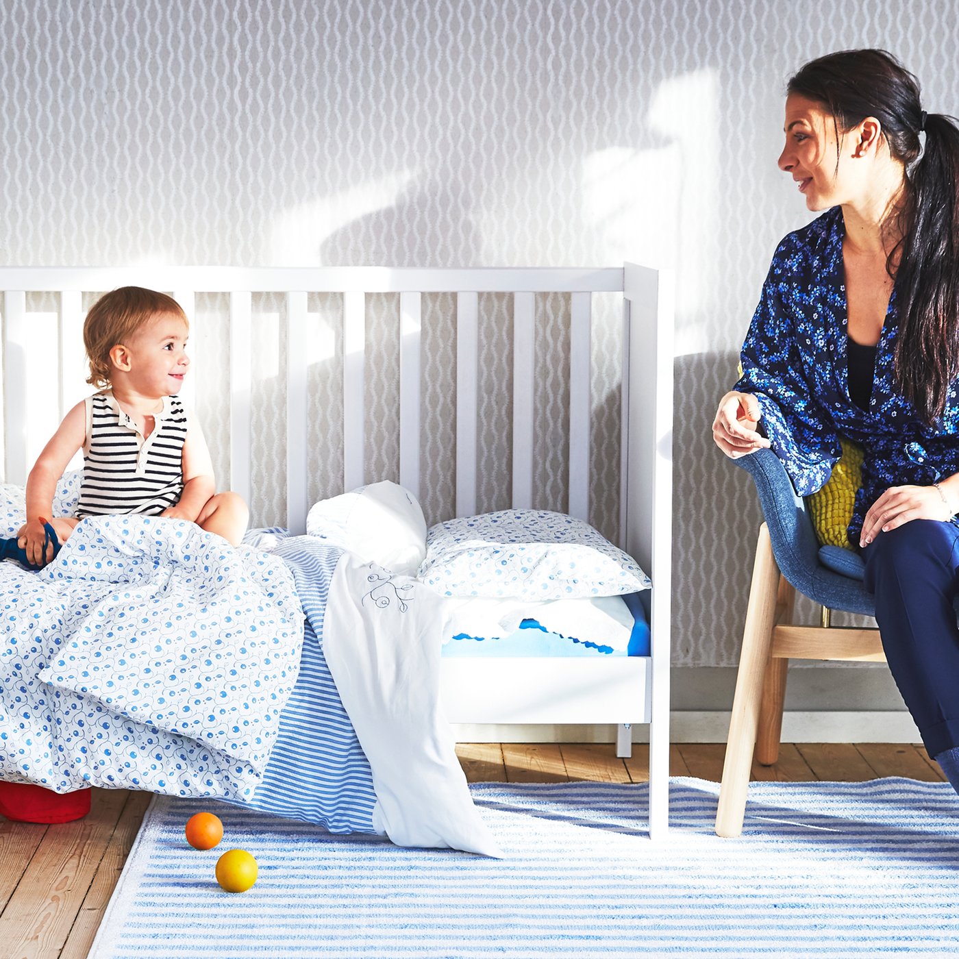 Mère observant son enfant dans sont lit modulable.