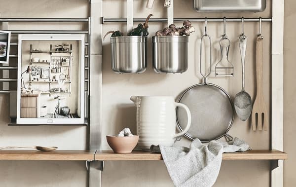 Metal rails and wooden shelves storing kitchen items.