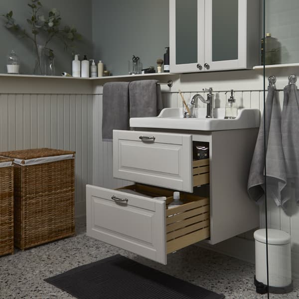 Meuble lavabo/lavabo GODMORGON/RÄTTVIKEN gris clair/blanc avec deux grands tiroirs ouverts et armoire à miroir au-dessus.
