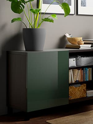 Meuble vert avec une plante posé dessus.