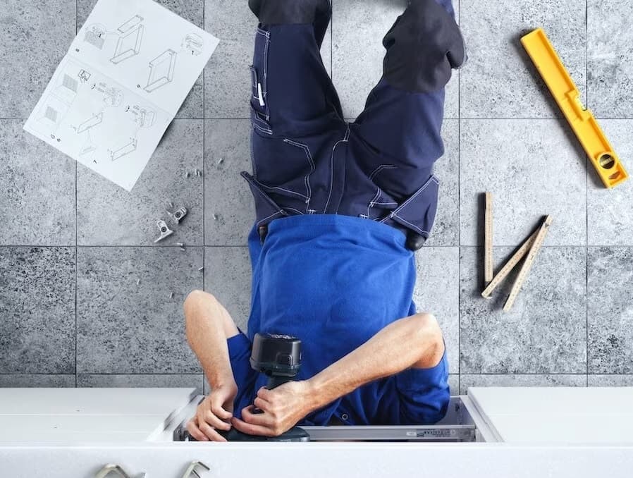 mężczyzna leżący na ziemi i montujący meble