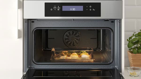 Micro-onde ouvert avec un plat de poissons à l'intérieur