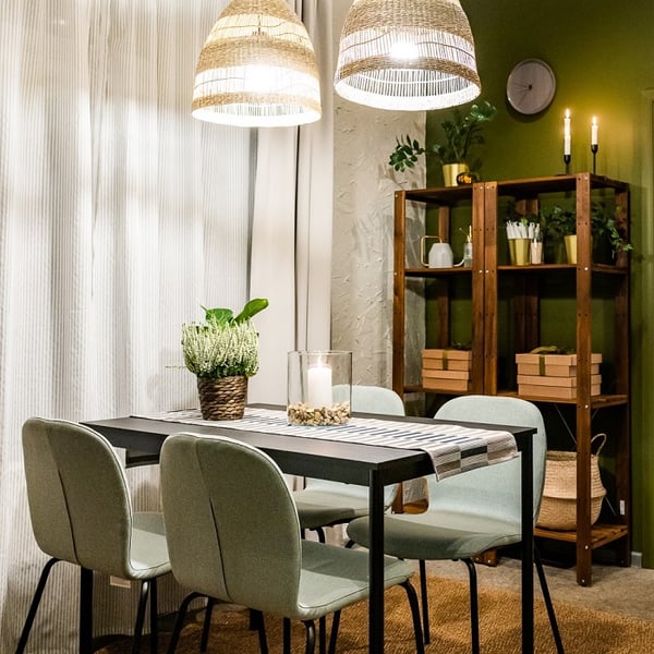 Minimalist dining table with candle centerpiece and indoor plants