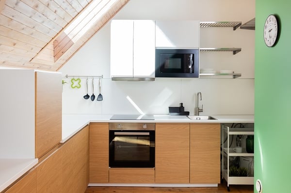 Minimalist kitchen interior with built-in oven, microwave, and wooden countertops