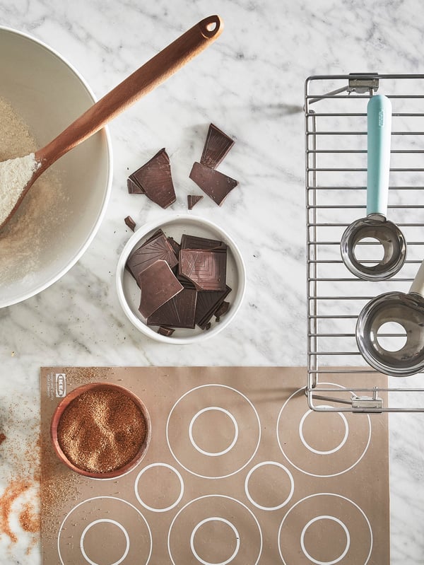 Misa s múkou, v ktorej je lyžica RÖRT, vedľa nej je mriežka LÄTTBAKAD a na nej odmerky LÄTTBAKAD a ďalej podložka na pečenie BAKTRADITION s miskou trstinového cukru.