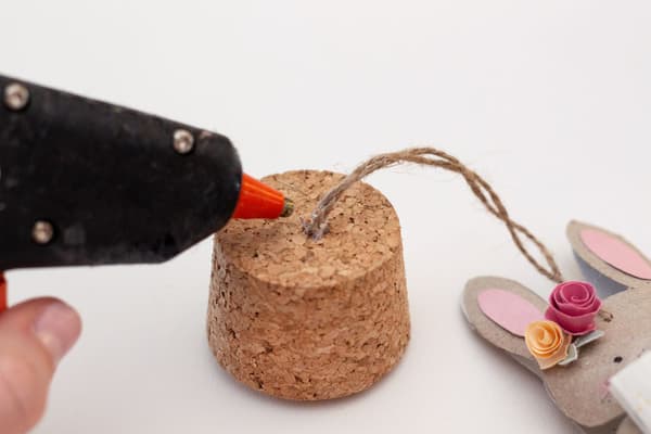 Mit eienr Heißklebepistole wird die Schnur vom Häschen an den Deckel geklebt. 