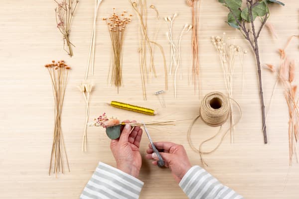 Mit eienr Schere wird das Sträußchen gekürzt.