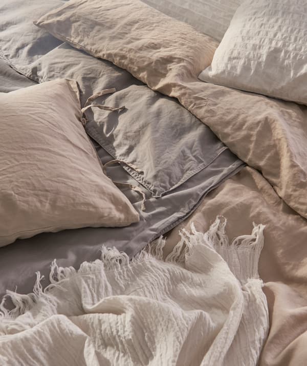 Mixing shades and textures of bed linen creates an inviting, cozy bedding arrangement.