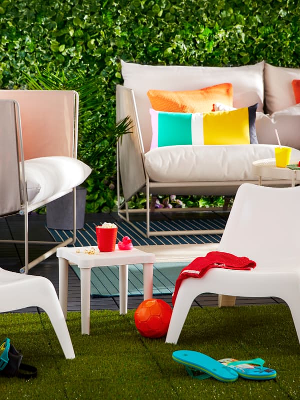 Mobilier d’extérieur composé d’un canapé, d’un fauteuil, de chaises pour enfants et d’une table avec des coussins et divers articles.