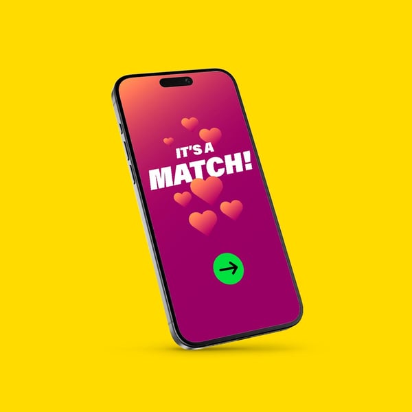 Mobiltelefon med rosa-lila skärm som visar texten ”IT’S A MATCH!” och hjärtan, mot gul bakgrund.