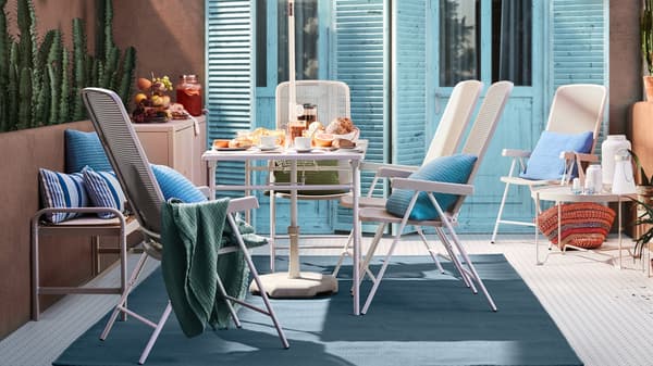 Møbler fra TORPARÖ serien der står udenfor på en terrasse foran lyseblå havedøre.
