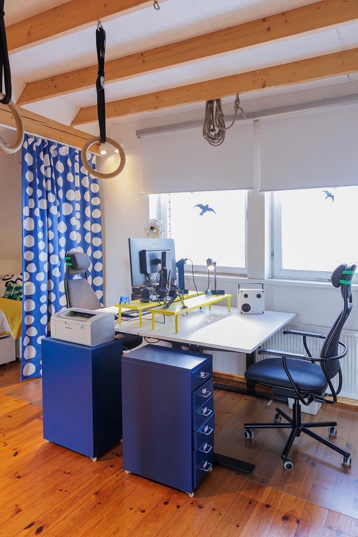 Modern desk setup with monitor, chair and storage drawers in kids room