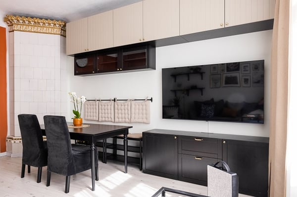 Modern dining and living area with built-in cabinets, dining table, and large wall-mounted TV