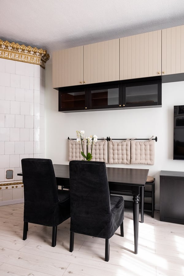 Modern dining area with black table, upholstered chairs, and built-in wall cabinets