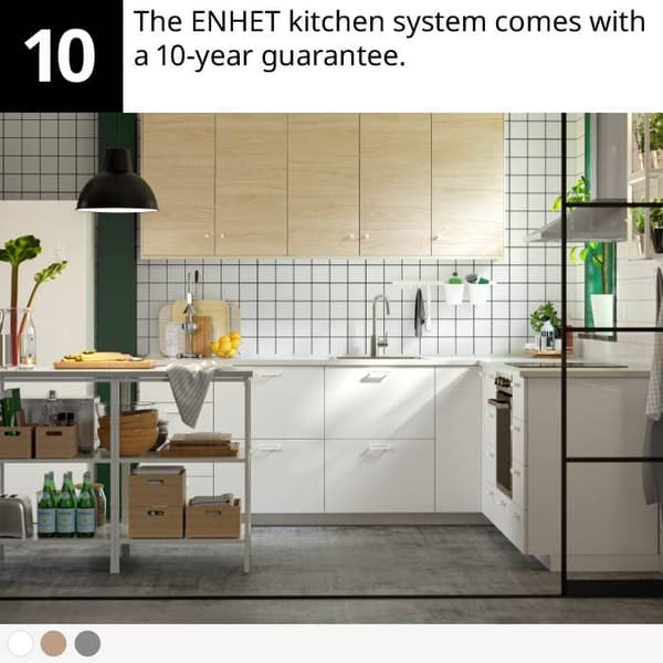 Modern kitchen with white cabinets, wood upper units, metal island, plants, and kitchen accessories.