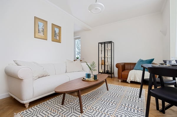 Modern living room with white sofa, wooden coffee table, and patterned rug