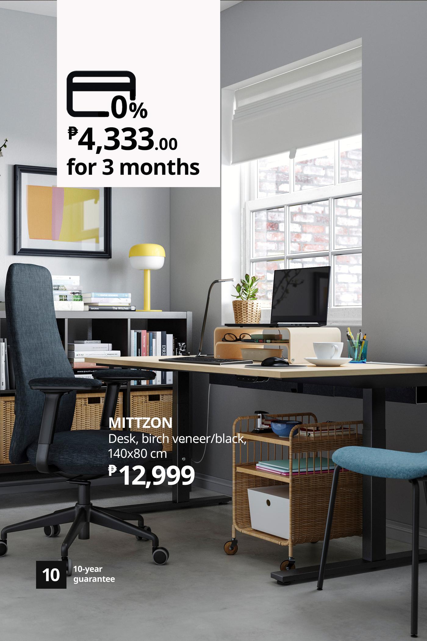 Modern Mitzon desk with a black chair, computer and storage beneath a bright window; ad highlights a ₱12,999 price and installment offer.