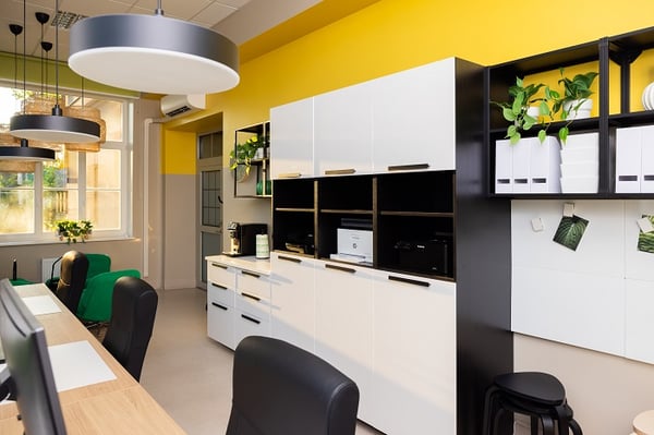 Modern office interior with white storage cabinets, yellow walls and indoor plants