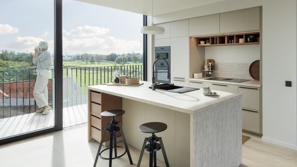 Modern open kitchen in sand colour with a spacious kitchen island with bar stools