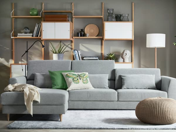 Modern SLATORP gray sofa with shelves and lamp.