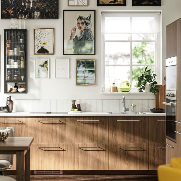 Modern wood effect kitchen with white ceramic worktop and golden handles.