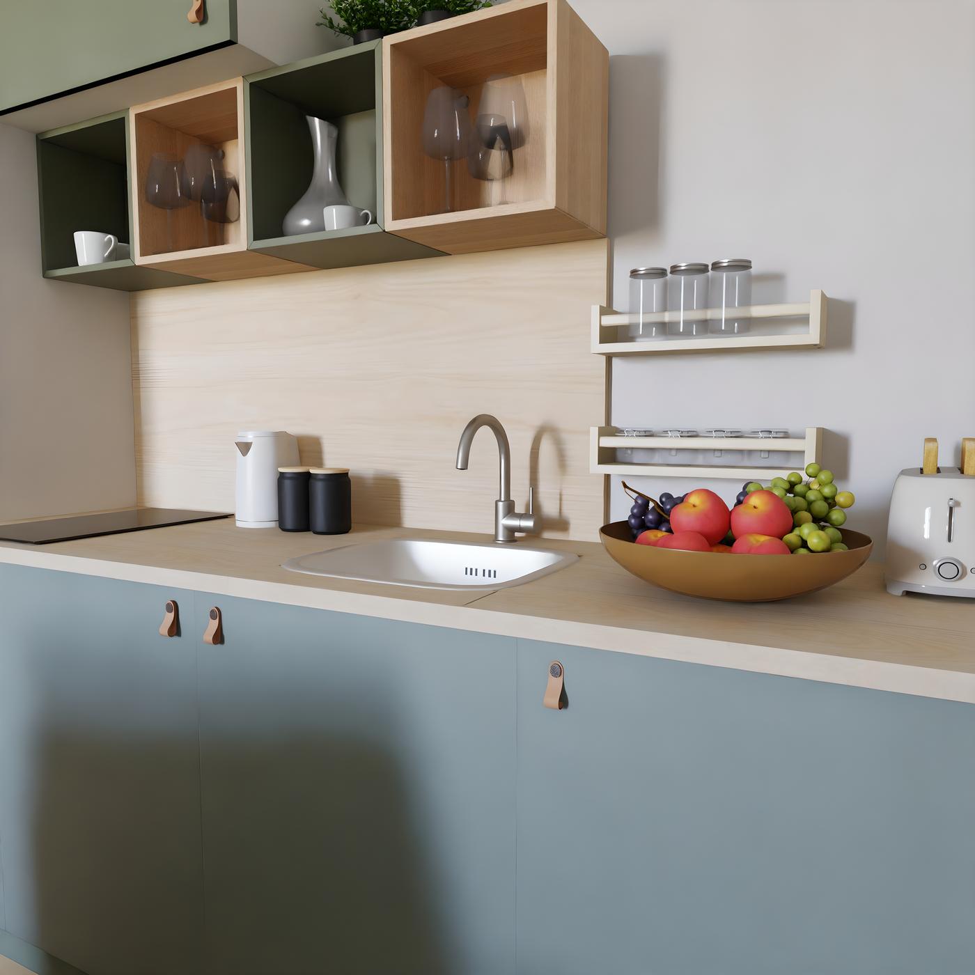 Moderna kuhinja s plavim ormarićima, bijelim sudoperom, zdjelom voća i tosterom na radnoj površini.
