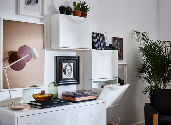 Modernes Wohnzimmer, in dem an einer Wand drei TRONES Aufbewahrungen in Weiss als Blickfang platziert sind.