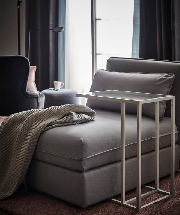 Módulo de asiento gris con un soporte para portátil cerca.