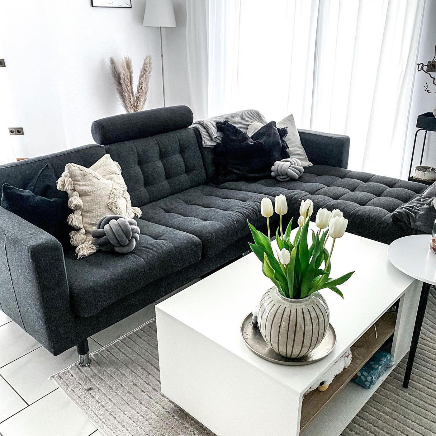 Mörkgrå LANDSKRONA soffa tillsammans med ett vitt soffbord. 